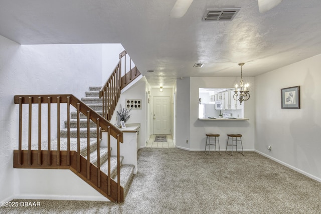 stairway featuring carpet, a chandelier, and baseboards
