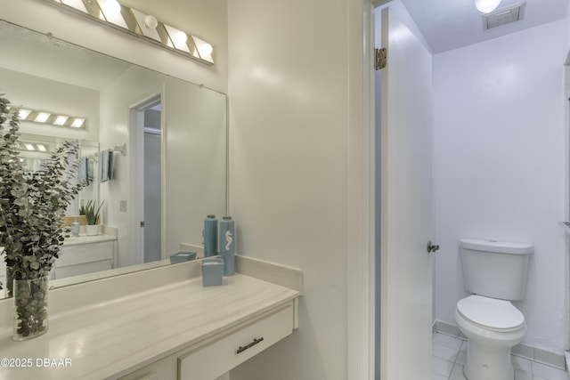 bathroom with tile patterned flooring, toilet, vanity, and baseboards