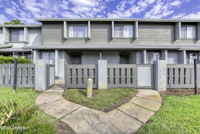 view of property featuring a fenced front yard, stucco siding, and a gate