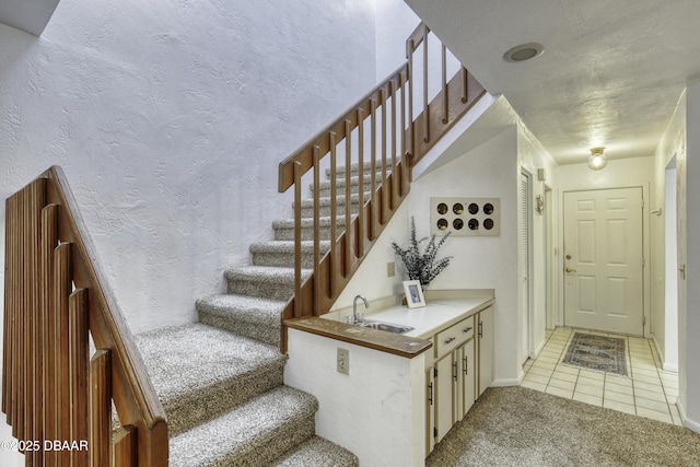 staircase with carpet, tile patterned flooring, and baseboards