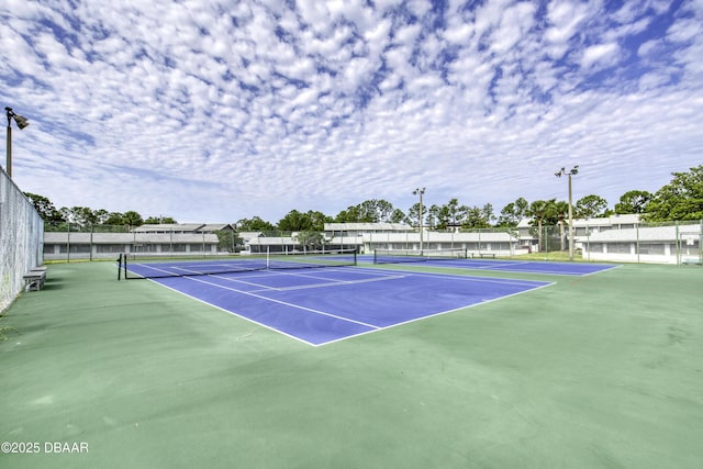 view of tennis court featuring fence