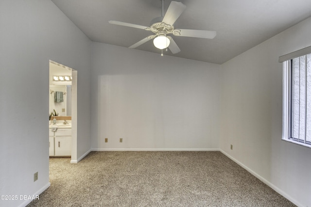 unfurnished bedroom with carpet, baseboards, a sink, connected bathroom, and a ceiling fan