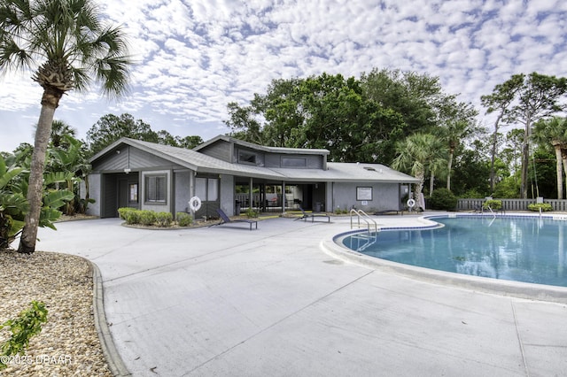 community pool featuring a patio area and fence