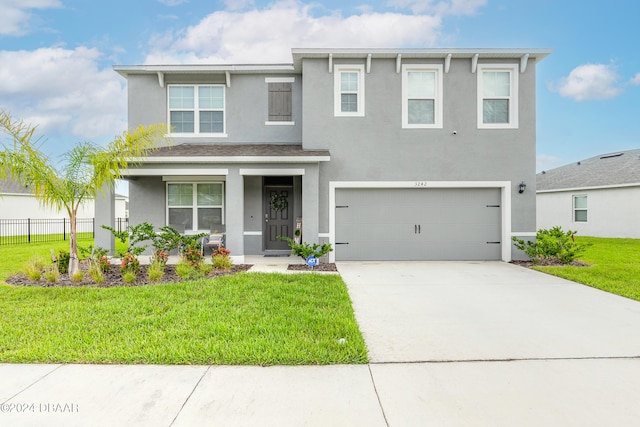 view of front of home featuring a front lawn, a garage, and a porch