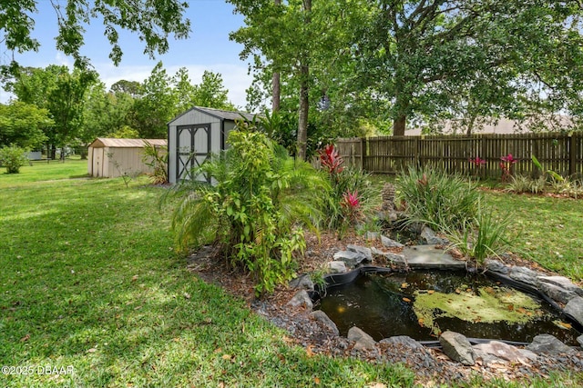 16 Powder Hill Ln, Palm Coast, FL 32164 - view of yard featuring a small pond, an outdoor structure, fence, and a storage shed