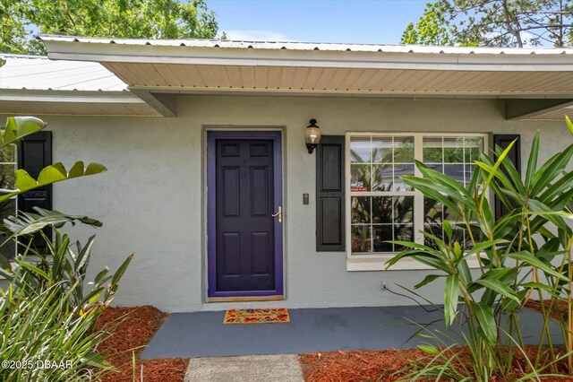 16 Powder Hill Ln, Palm Coast, FL 32164 - doorway to property featuring metal roof and stucco siding