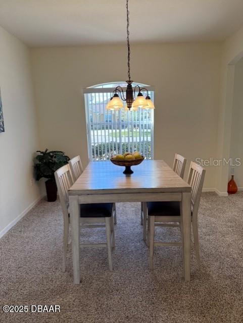 unfurnished dining area featuring carpet flooring and an inviting chandelier