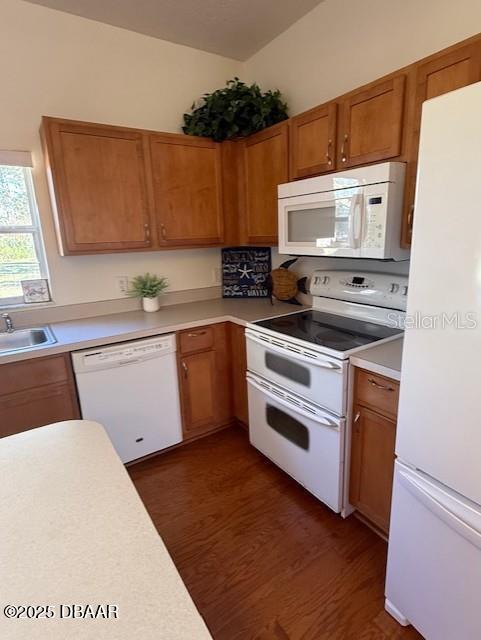 kitchen featuring sink, white appliances, and dark wood-type flooring