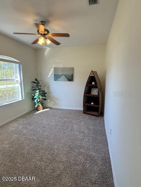 interior space with carpet floors and ceiling fan