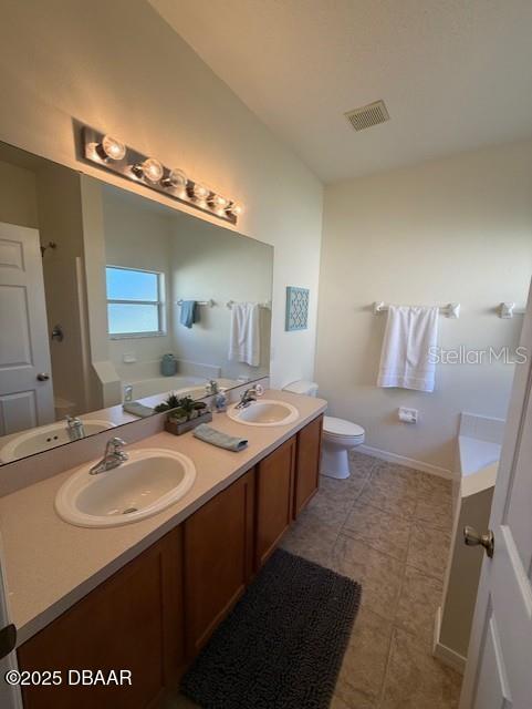 bathroom featuring a bathtub, toilet, and vanity