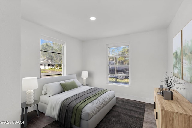 bedroom with dark wood-style floors, recessed lighting, multiple windows, and baseboards