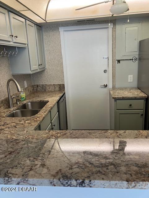 kitchen with decorative backsplash, gray cabinetry, and sink