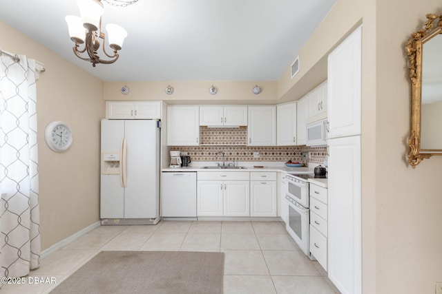 kitchen featuring white cabinetry, sink, backsplash, light tile patterned floors, and white appliances