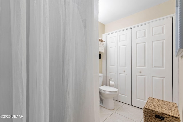 bathroom featuring toilet and tile patterned flooring