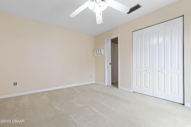 unfurnished bedroom featuring light carpet, ceiling fan, and a closet