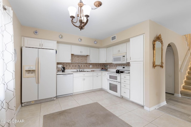 kitchen with white cabinetry, sink, light tile patterned flooring, and white appliances