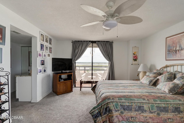 carpeted bedroom featuring a textured ceiling and ceiling fan