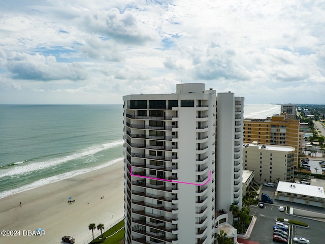 view of property with a water view and a beach view