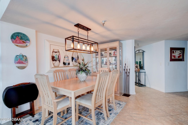 tiled dining room with a chandelier