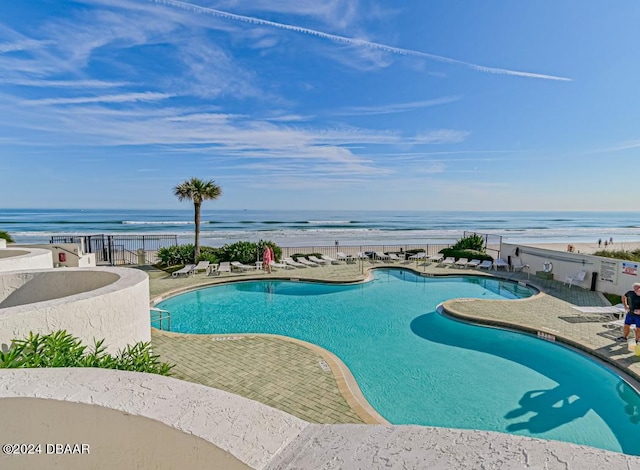 view of swimming pool with a patio area and a water view