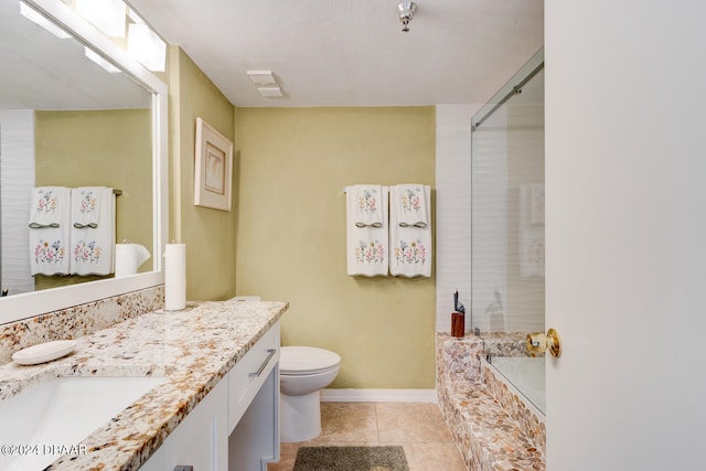 bathroom with a bathing tub, toilet, vanity, and tile patterned floors