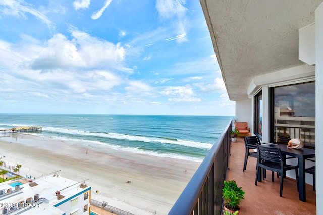 balcony featuring a water view and a beach view