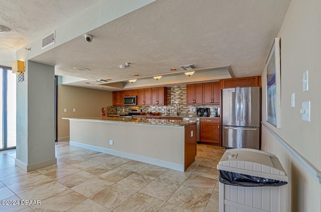 kitchen with plenty of natural light, backsplash, a textured ceiling, and stainless steel appliances