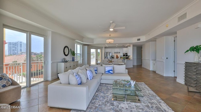 living room featuring ceiling fan and ornamental molding