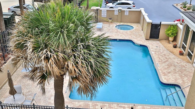 community pool with fence and a patio area