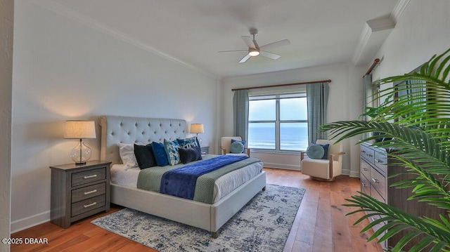 bedroom with ornamental molding, light wood-style flooring, baseboards, and ceiling fan