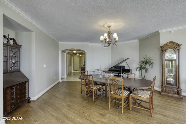 2300 N Atlantic Ave Unit 303, Daytona Beach, FL 32118 - dining room featuring arched walkways, ornamental molding, a chandelier, wood finished floors, and baseboards