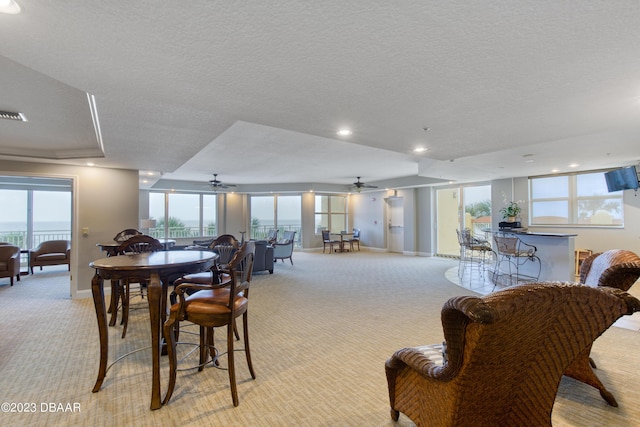 2300 N Atlantic Ave Unit 303, Daytona Beach, FL 32118 - dining room featuring baseboards, a ceiling fan, light colored carpet, and a textured ceiling