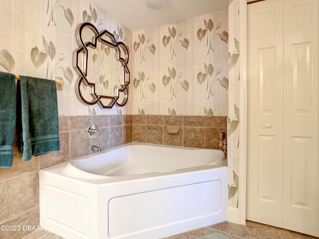 bathroom featuring tile walls, tile patterned flooring, and a bath