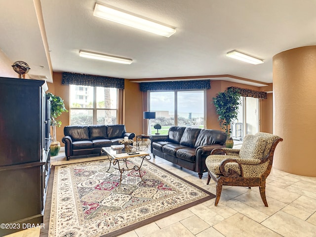 tiled living room with a healthy amount of sunlight and crown molding