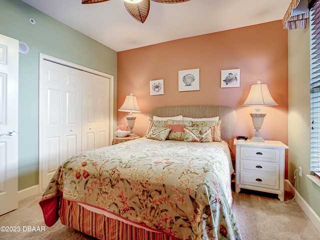 bedroom with ceiling fan, light carpet, and a closet