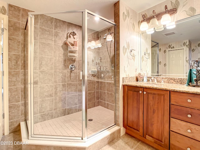 bathroom with a shower with shower door and vanity