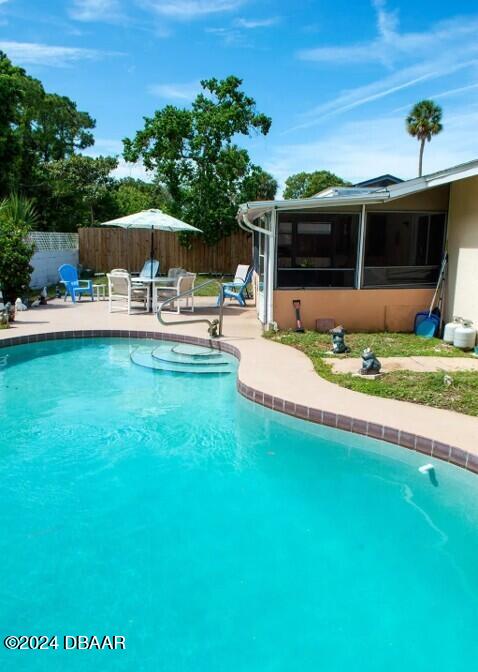 view of pool featuring a sunroom and a patio