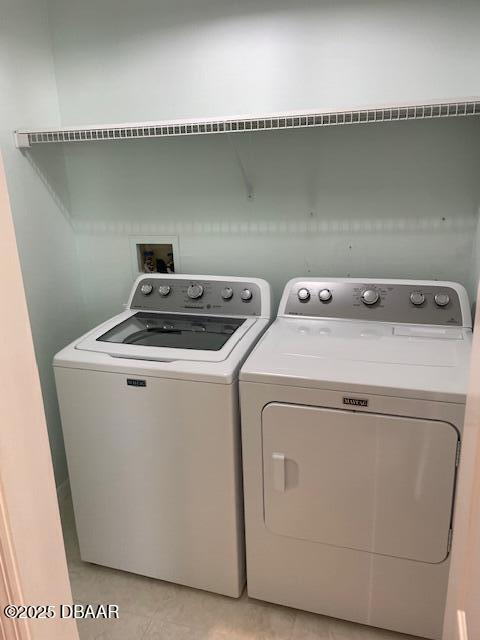 laundry area with light tile patterned flooring and independent washer and dryer