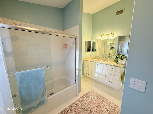 bathroom with tile patterned flooring, vanity, and bath / shower combo with glass door