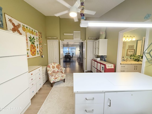 kitchen with light hardwood / wood-style floors, white cabinetry, and ceiling fan