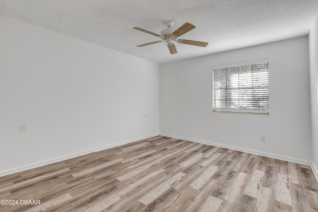 empty room featuring light wood-type flooring, a textured ceiling, and ceiling fan