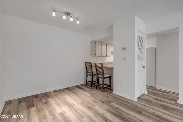 kitchen with light hardwood / wood-style floors and a textured ceiling