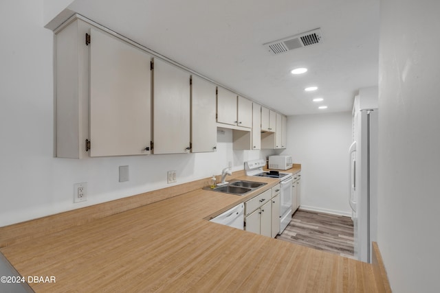 kitchen featuring white cabinets, light hardwood / wood-style floors, sink, and white appliances