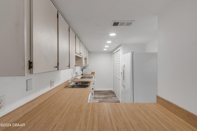 kitchen with white cabinetry, light wood-type flooring, sink, and white refrigerator with ice dispenser