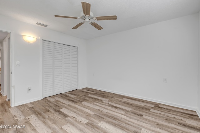 unfurnished bedroom with ceiling fan, a closet, and light hardwood / wood-style flooring