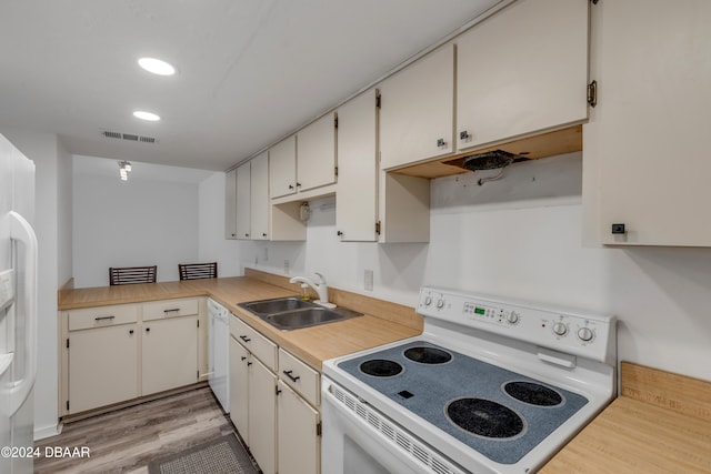 kitchen with white cabinetry, light hardwood / wood-style flooring, sink, and white appliances