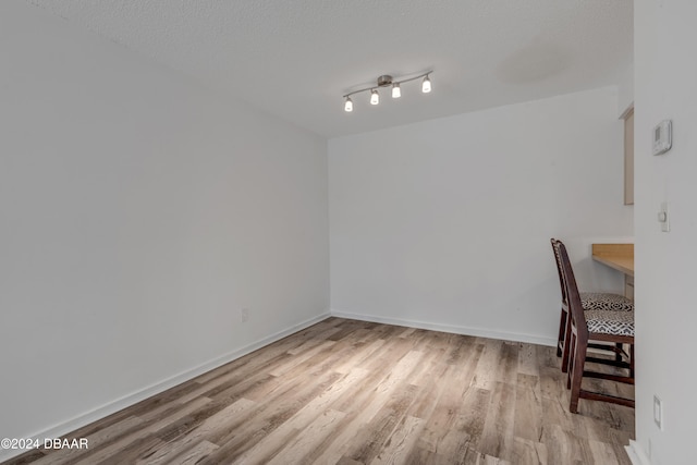 interior space with a textured ceiling and light hardwood / wood-style flooring