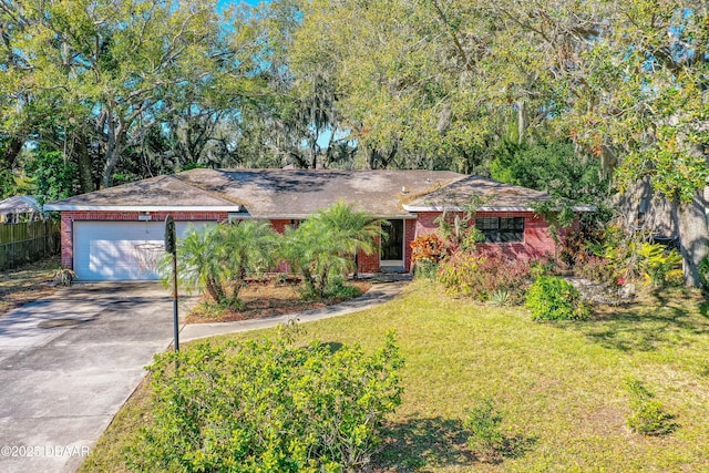 ranch-style home featuring concrete driveway, brick siding, an attached garage, and a front yard