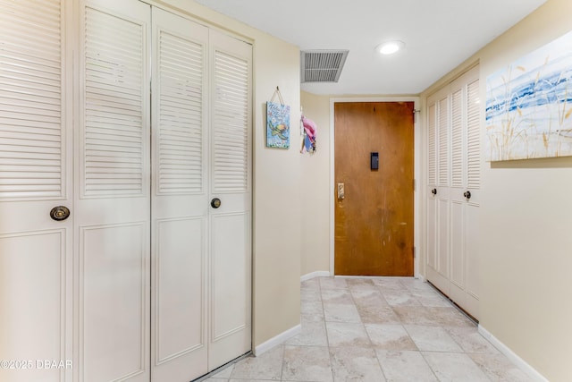 hall with baseboards and visible vents