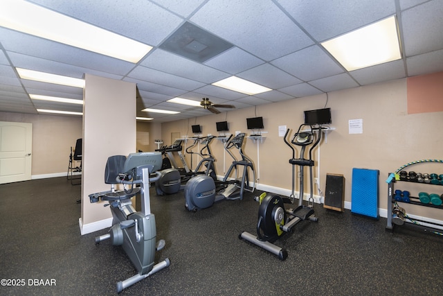 exercise room with a drop ceiling, baseboards, and a ceiling fan